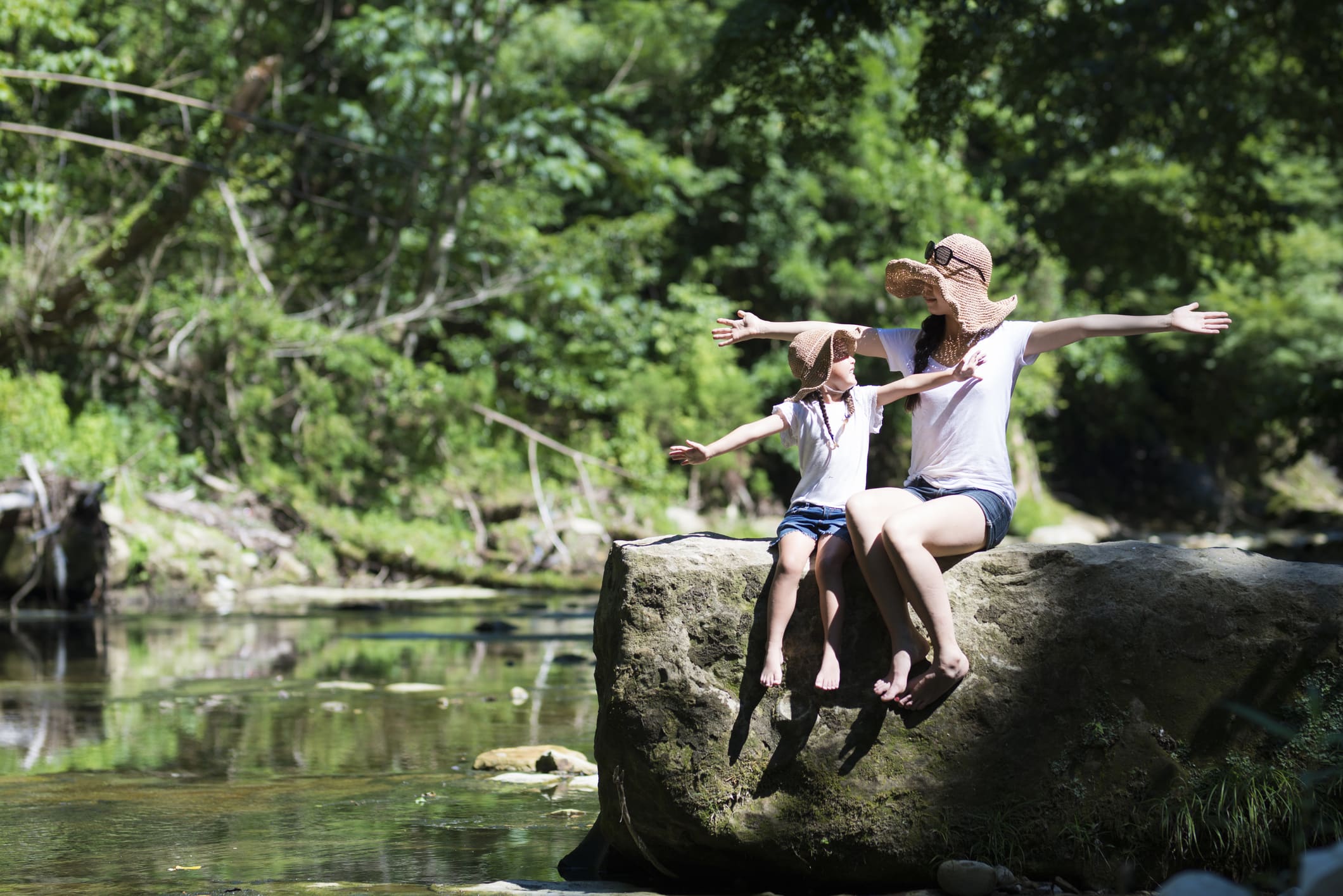 Mother and daughter playing in mountain stream