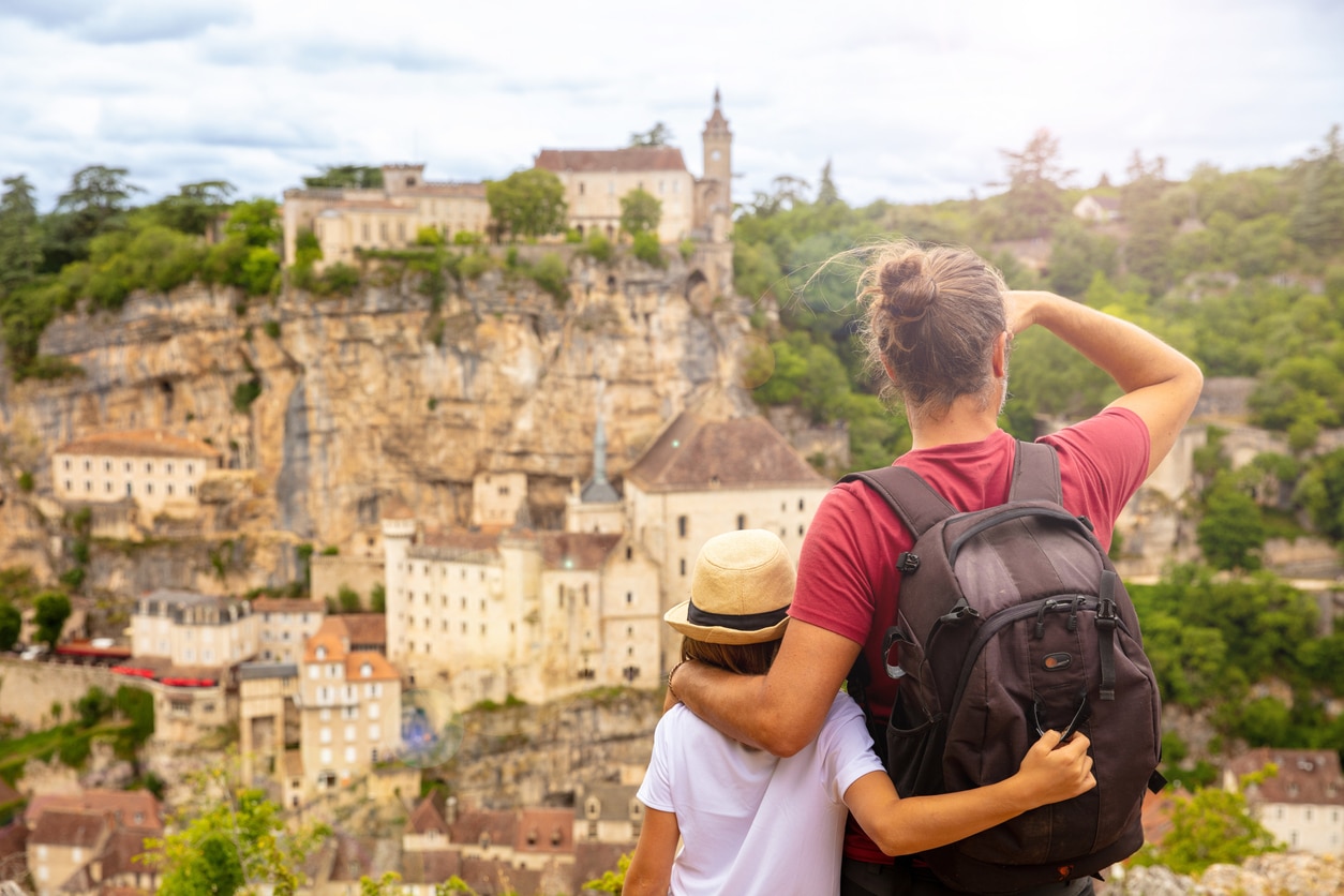 pere et son fils de dos devant la ville de Rocamadour France