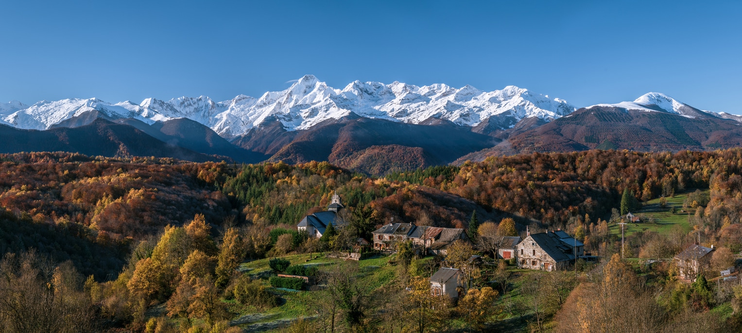 village de montagne en ariege devant montagne enneigée