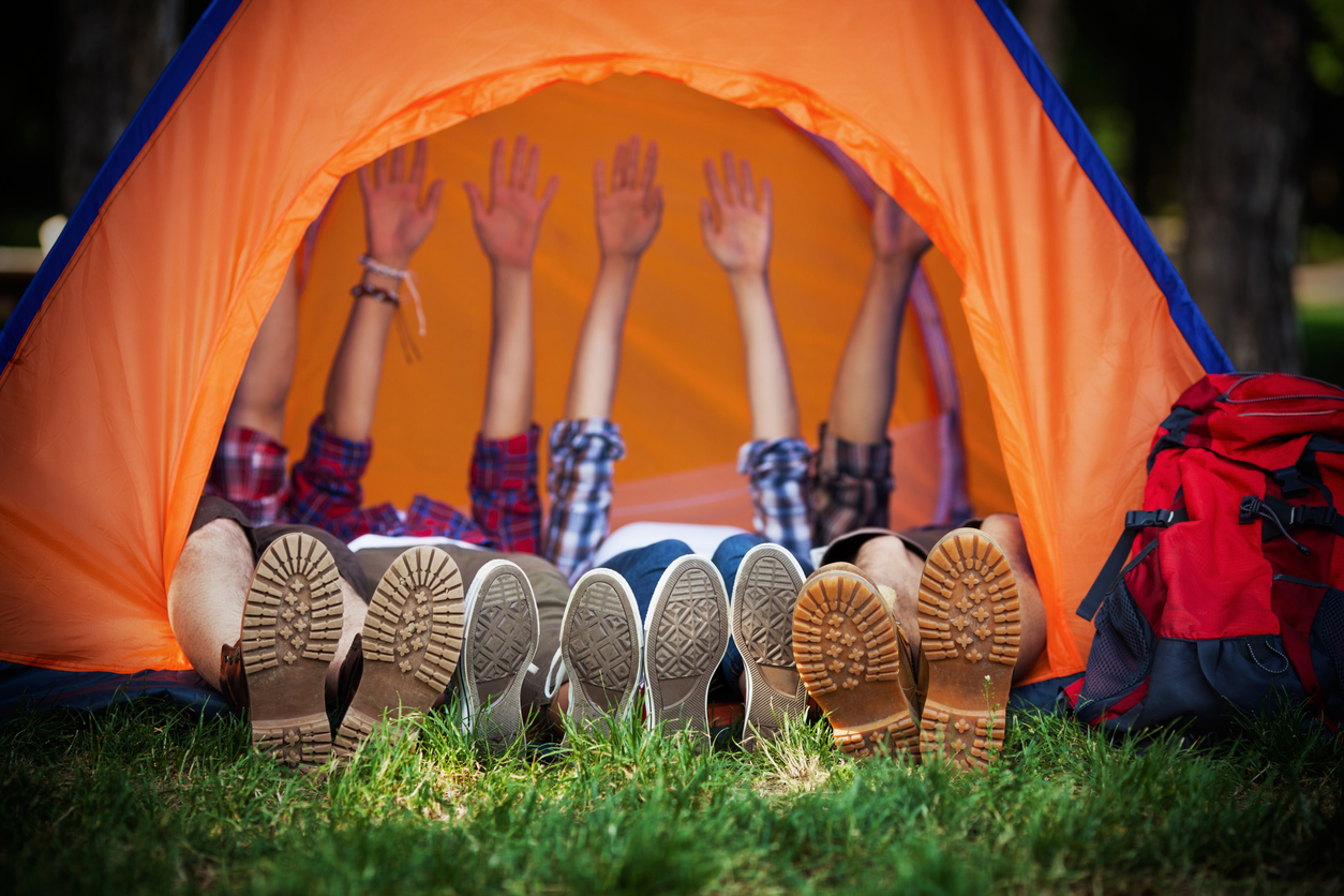 des pieds de campeurs dans une tente