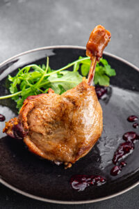 duck leg confit with berry sauce poultry meat second course vegetable delicious healthy eating cooking appetizer meal food snack on the table copy space